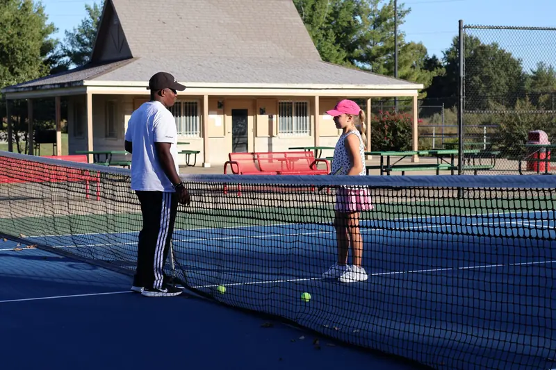 Coach Kuda talking with a junior player at the net